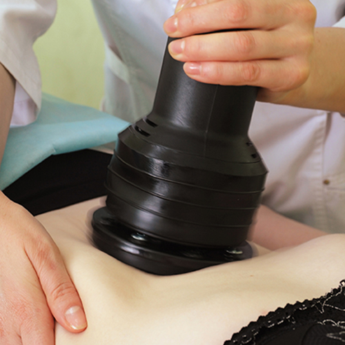 Especialista realizando un masaje manual de drenaje linfático postoperatorio para reducir la inflamación a una paciente.